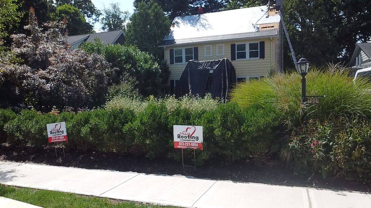 All Heart Roofing lawn signs at job site